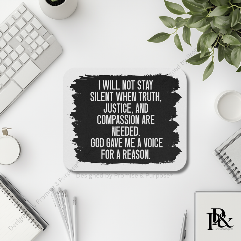 Desk setup with a motivational quote coaster, keyboard, and plant.